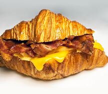 Круассан с беконом, омлетом скрэмбл, сыром чеддер и пикантным томатным соусом