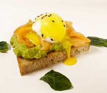 Яйцо пашот с лососем, гуакамоле и соусом голландез на тартине