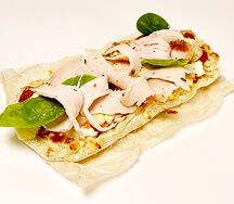 Пиццета с пастрами из индейки, сыром, томатным и сливочным соусом 