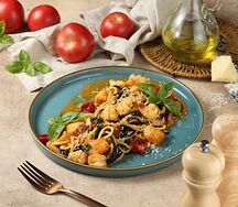 Черные спагетти с морепродуктами и соусом биск