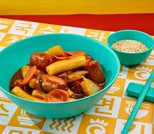 Токпокки с куриными колбасками и овощами в кисло-сладком соусе