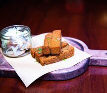 Тихоокеанская сельдь с маринованным луком и ржаными тостами