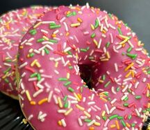 Пончик-донатс с клубничной начинкой и розовой глазурью с цветной посыпкой