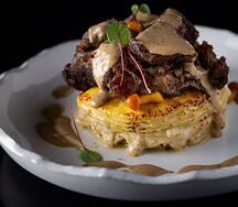 Картофельная запеканка с томлеными щечками и перечным соусом