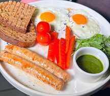 Глазунья с колбасками, овощами и соусом песто