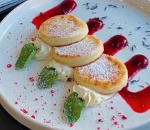 Сырники с клюквенно-малиновым кули и сливочным муссом