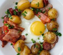 Жареная картошка с грудинкой, колбасками и глазуньей