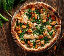 Пицца с морепродуктами, моцареллой, шпинатом и соусом биск