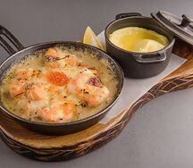 Окунь, запеченный с соусом бешамель на подушке из пассерованного лука с шампиньонами 