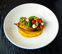 Запеченный баклажан с сыром сулугуни, томатами, подается с хумусом