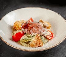 Салат из копчёной утки с миксом салата, томатами и гренками