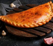 Закрытая пицца кальцоне с ветчиной и грибами
