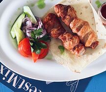 Шашлык из куриного бедра подается с овощами, тортилья пшеничная и томатным соусом