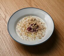 Овсяная каша с брусничным соусом и халвой