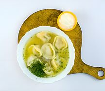 Пельмени из говядины с бульоном и сметаной