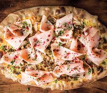 Пицца с итальянской ветчиной, солеными грибами и розовым перцем
