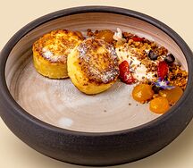 Сырники с соусом из манго, сметаной и ягодами 