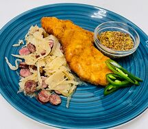Шницель cвинoй с тушеной капустой и копченными колбасками